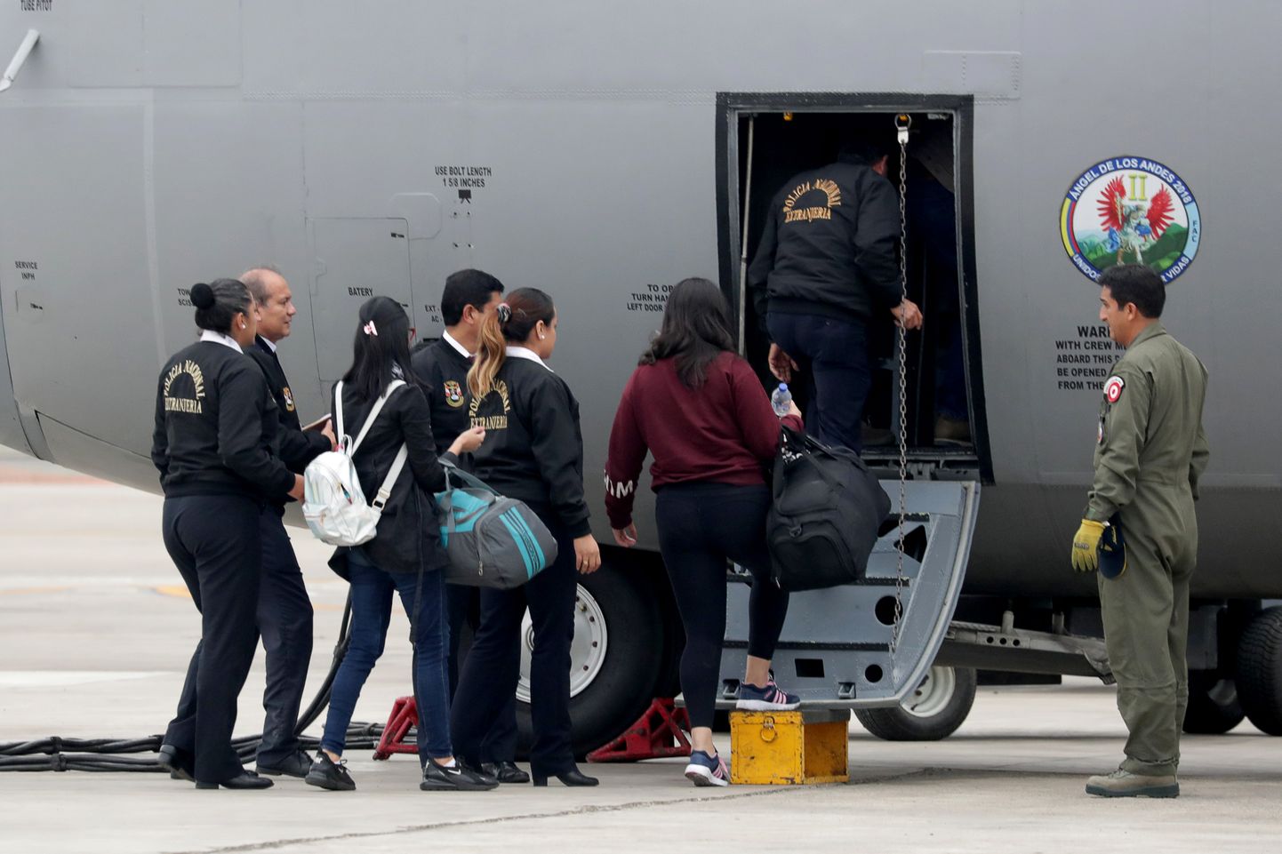 Peruu migratsiooniametnikud Venezuela sisserändajaid lennukile panemas.