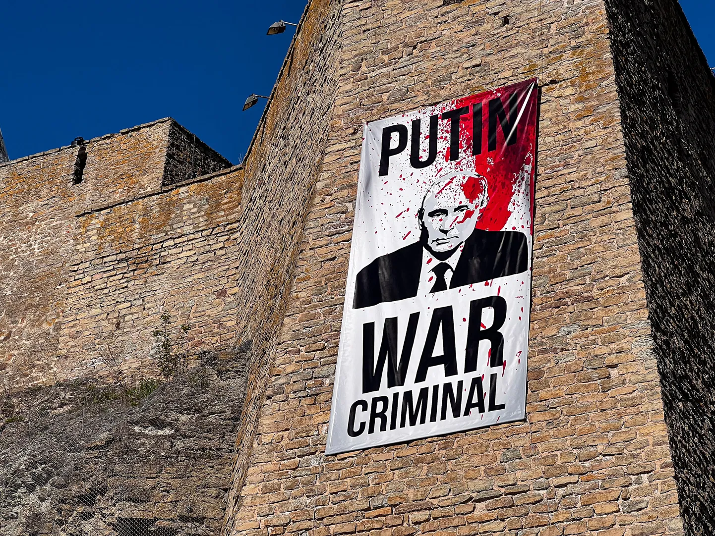К утру 9 мая 2023 года на стене Нарвского замка впервые был вывешен плакат с надписью "Putin war criminal" ("Путин - военный преступник"). В этом году плакат появится снова - так, чтобы быть достаточно хорошо видным с российского берега пограничной реки.