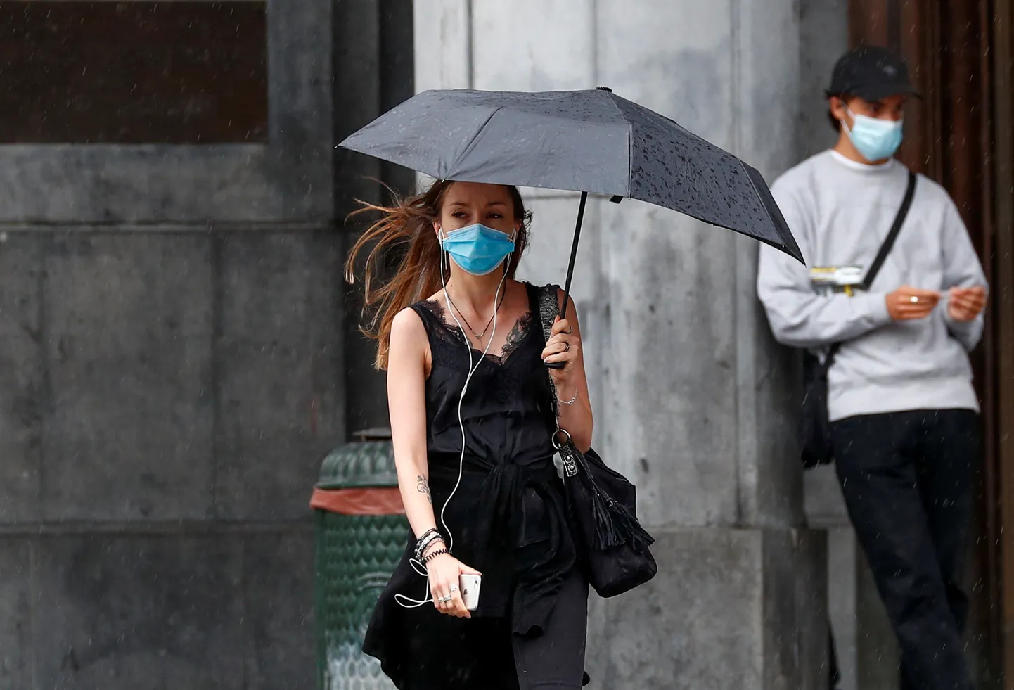 Sieviete ar lietussargu Covid-19 pandēmijas laikā