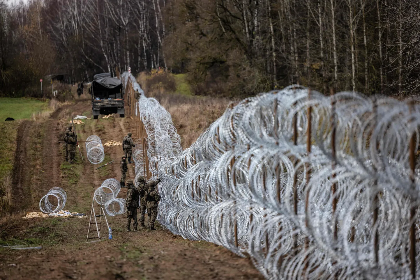 Польские солдаты строят забор из колючей проволоки на польско-российской границе в Калининградской области, 3 ноября 2022 года.