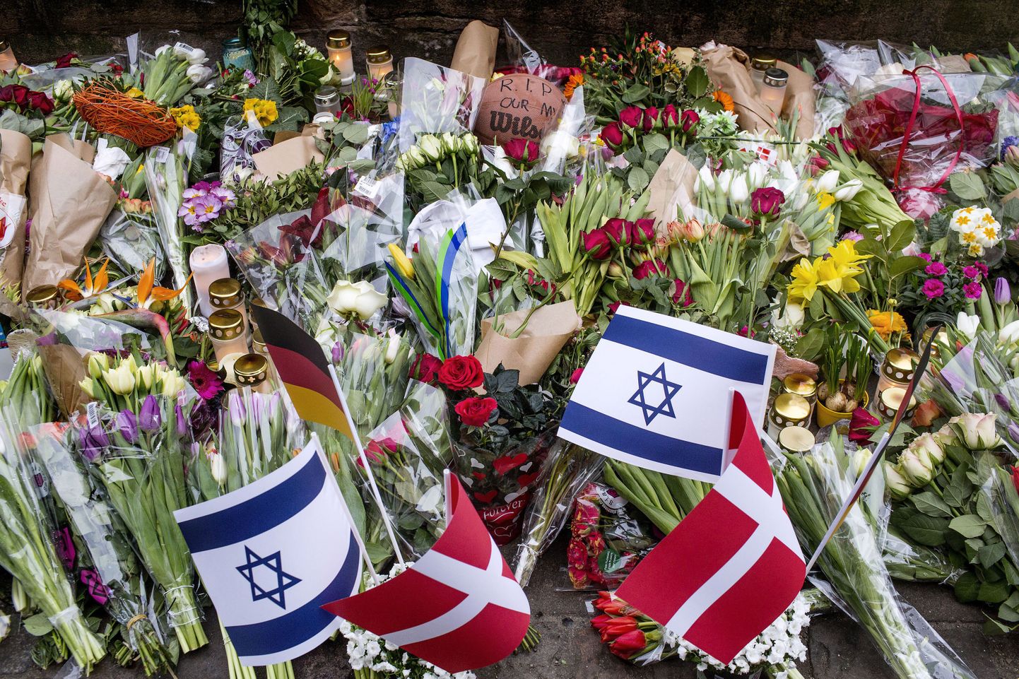 Taanis Kopenhaagenis maha lastud juudi mälestuseks toodud lilled ja lipud