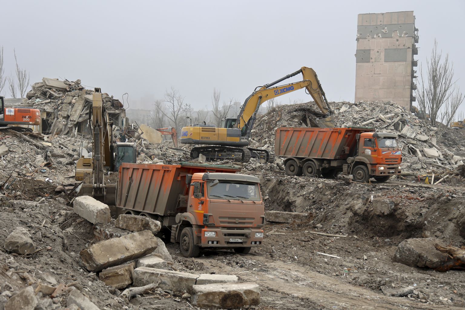 Töölised koristamas rususid ja hävitatud hooneid okupeeritud Mariupolis.