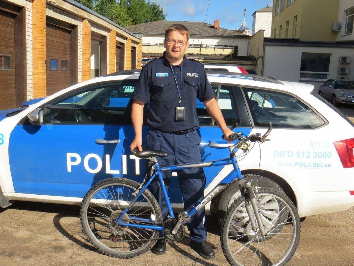 Полицейский с найденным велосипедом.