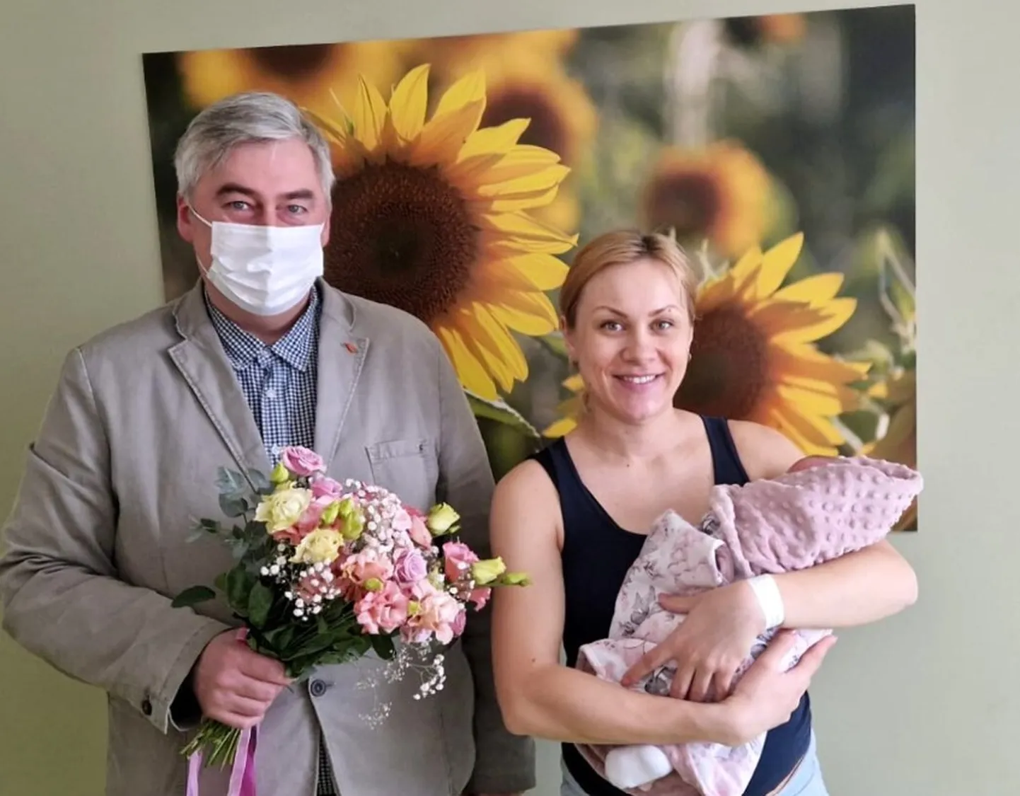 Māmiņu Inesi un mazulīti Melāniju sveic slimnīcas valdes priekšsēdētājs Juris Lācis.