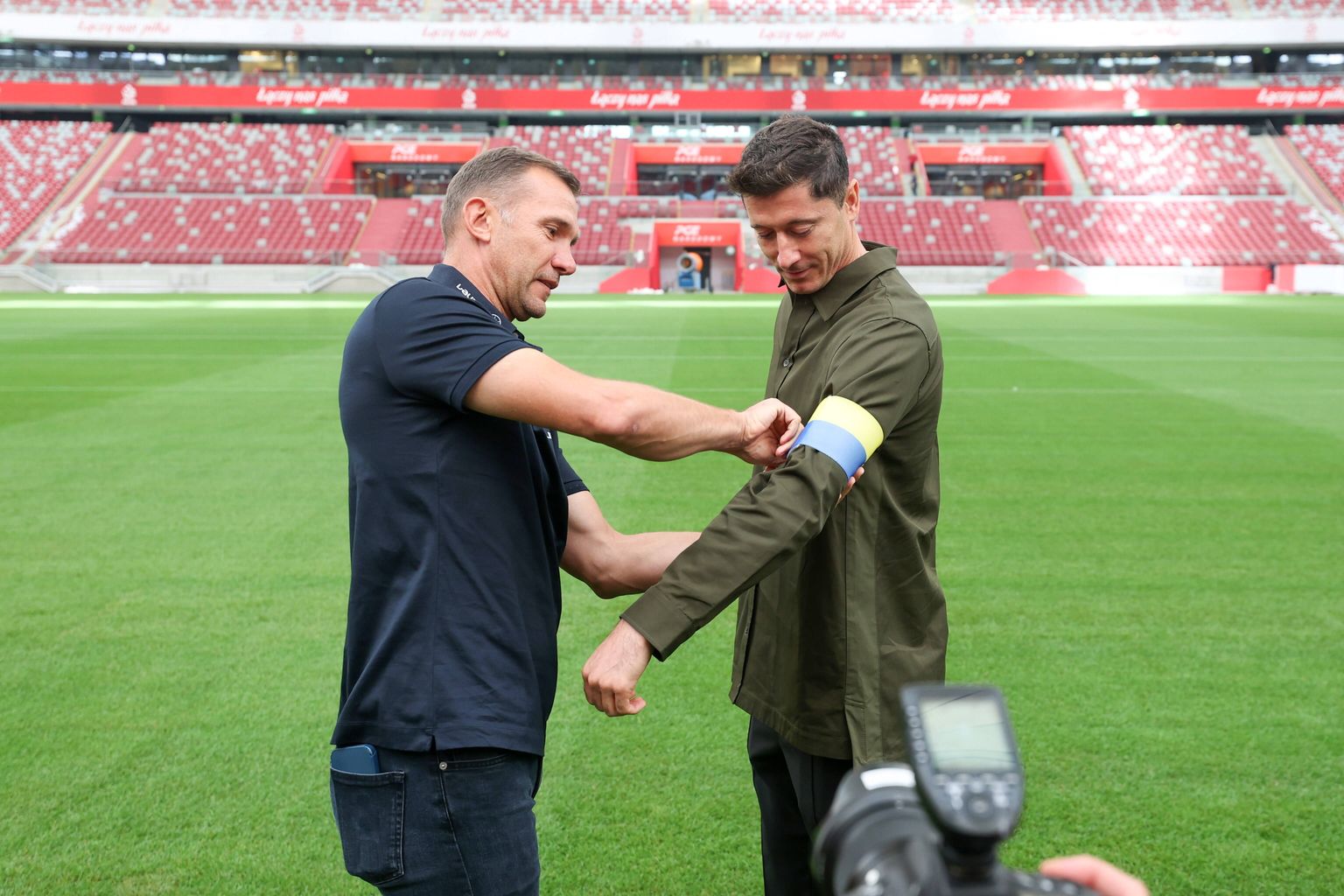 Ukraina koondise endine peatreener Andri Ševtšenko (vasakul) kinnitab Robert Lewandowski käe ümber sinikollase kaptenipaela.