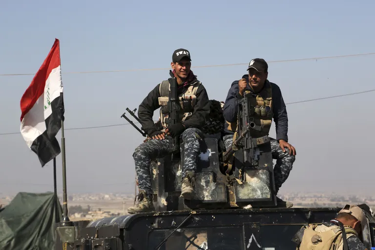 Two policemen sit atop of their armoured vehicle as Iraqi Federal police deploy after regaining control of the town of Abu Saif, west of Mosul, Iraq, Wednesday, Feb. 22, 2017. The battle for Mosul, backed by the U.S.-led coalition, has already driven the militants from the eastern half of the city, which is divided roughly in half by the Tigris River. (AP Photo/Khalid Mohammed)