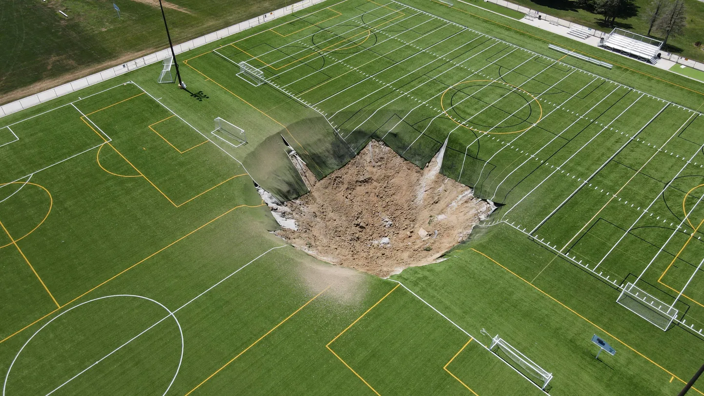 Droonivaates on näha vajumislehtrit, mis tekkis 27. juunil 2024 USAs Illinoisi osariigis Altonis Gordon Moore Parki murukattega jalgpalliväljakul.