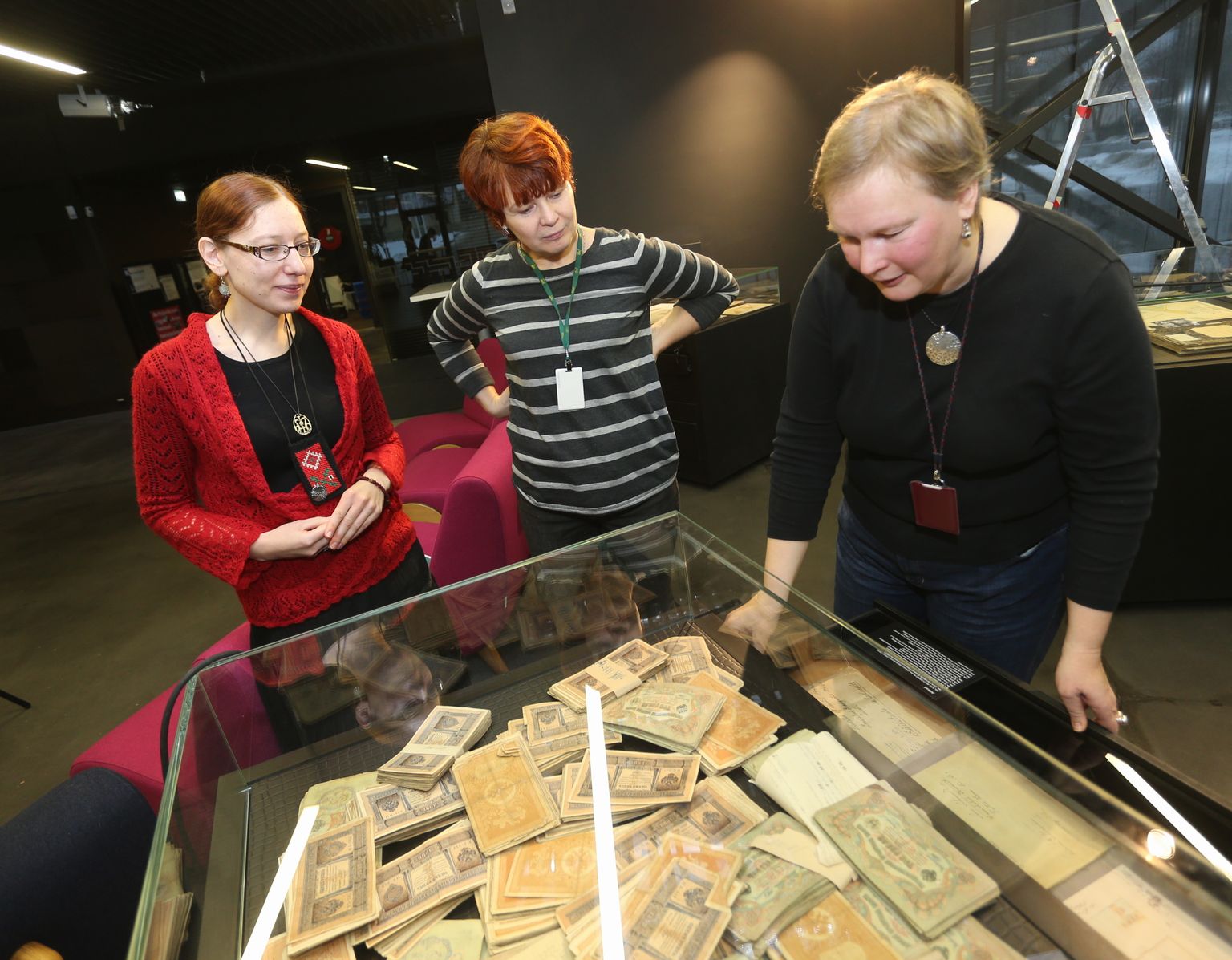 Näituse koostajad Maive Mürk (vasakult), Reet Hünerson ja 
Liina Lõhmus vitriini juures, mis sisaldab 5000 rubla 
vallaslapsele pärandatud 
raha.