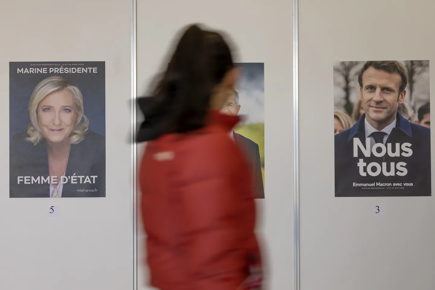 Valija kõndimas mööda Marine Le Peni ja Manuel Macroni valimisplakatist, et osaleda Prantsusmaa presidendivalimiste hääletusel.