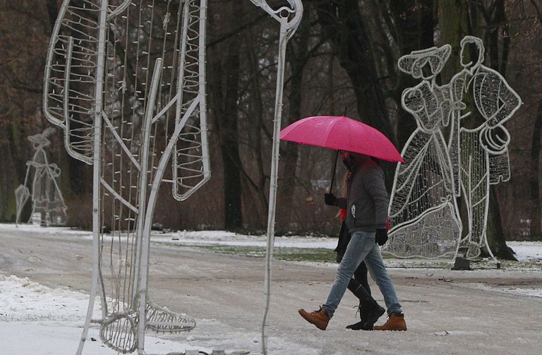 Paar jalutamas Poola pealinnas Varssavis, külmakaitseks ninani tõmmatud sallid ja vihmavari. Foto: AP Photo/Czarek Sokolowski/Scanpix