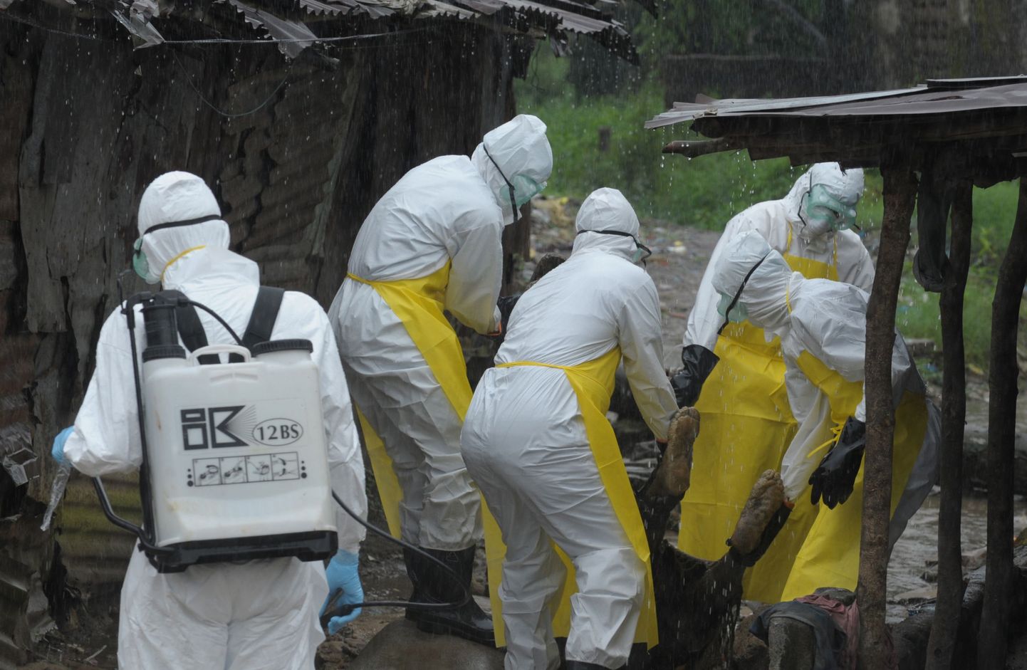 Libeeria terishoiutöötajad valmistuvad pealinnas Monrovias Ebola ohvri surnukeha minema toimetama.