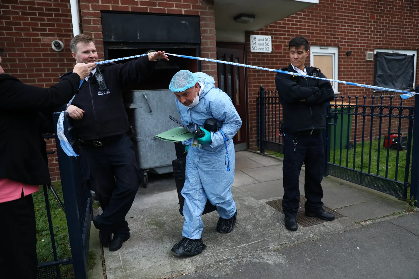 Politseinikud Ida-Londonis Canning Towni linnaosas maja ees, mille esimese korruse korteri külmikust leiti kahe naise surnukehad.