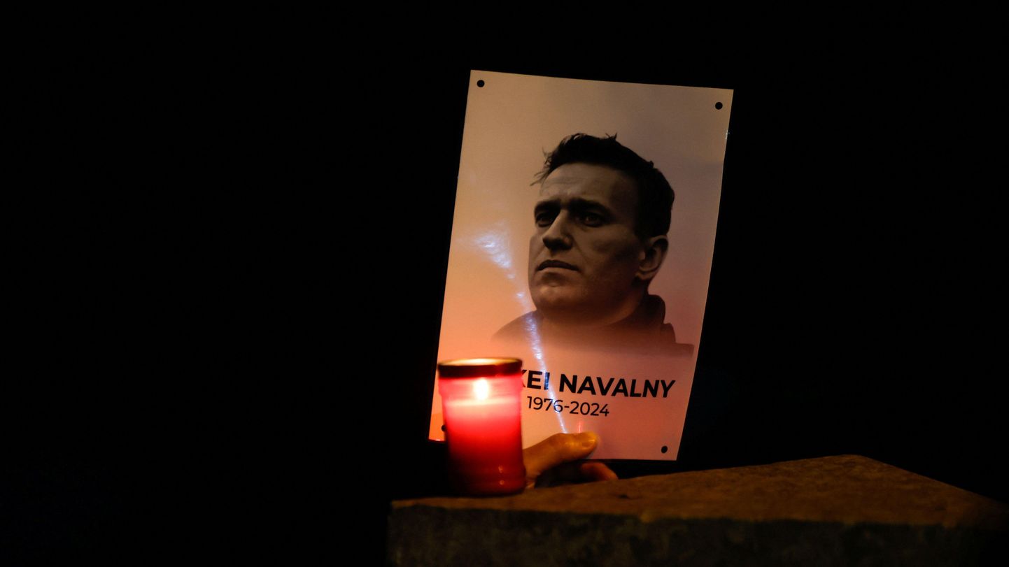 Могильная свеча возле плаката с изображением Алексея Навального.