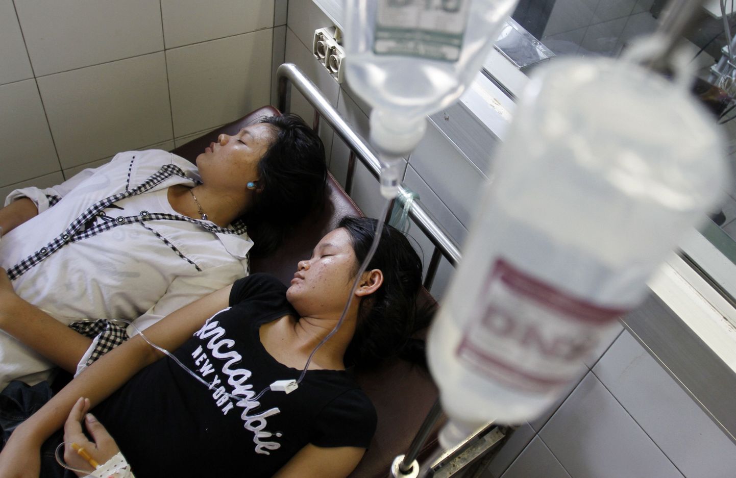 Kambodža tekstiilivabriku töölised haiglas tilgutite all pärast eelmist massilist minestamist juulis.