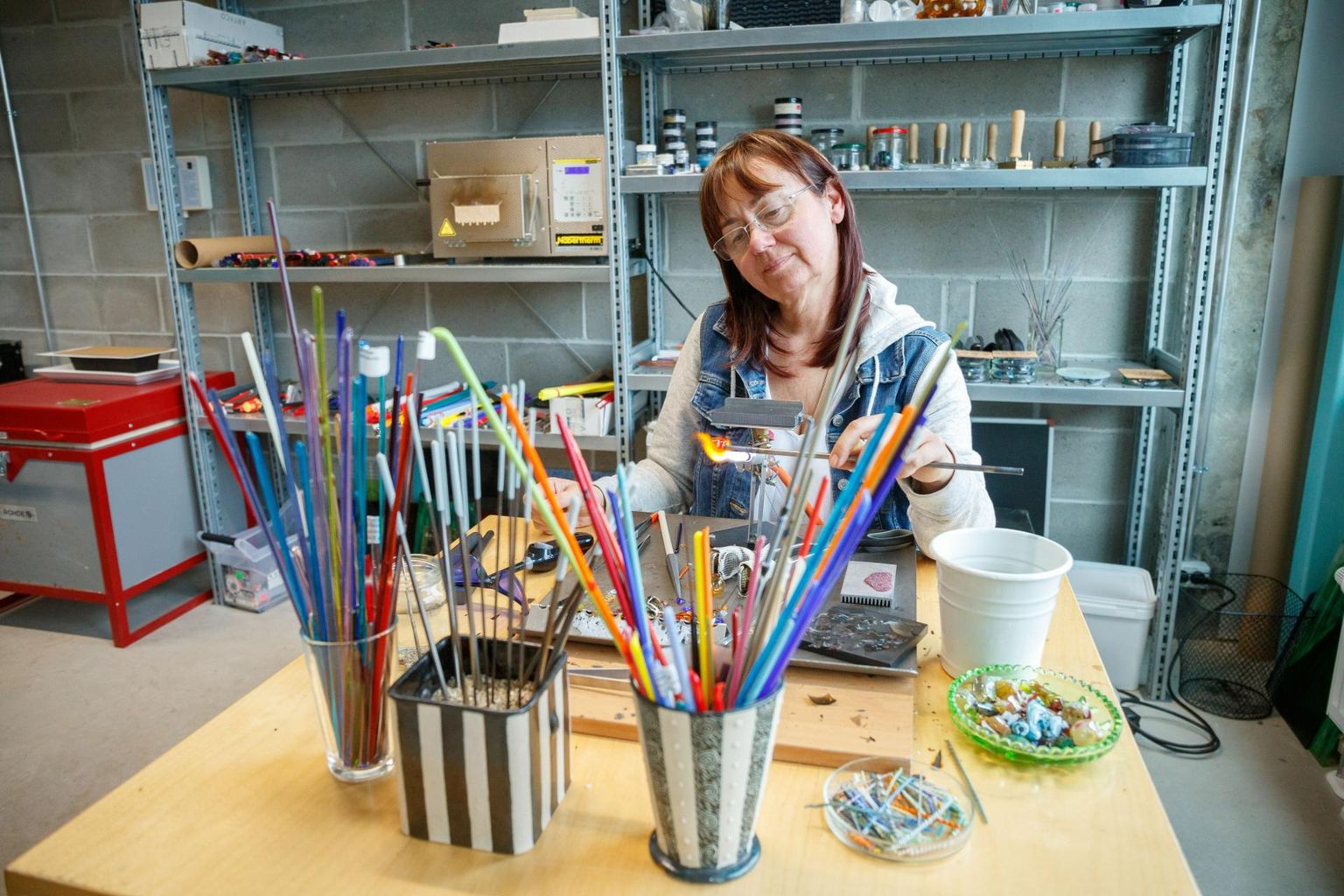 Mari-Liis Makus valmistab Naked Islandile loodud klaasikojas ehteid.