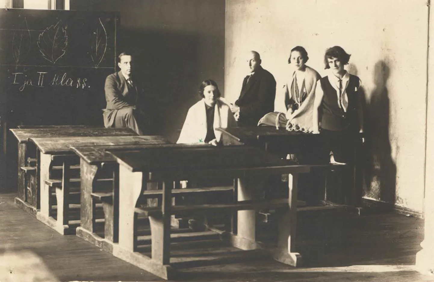 1928. aasta sügis Laupa mõisa häärberis: klassiruumid suures majas on koristatud, õpetajad ootavad lapsi kooli. Tahvli ees toetab tagumikku koolipingile tol sügisel Laupal koolijuhatajana alustanud Johannes Lohur, edasi õpetajad Irene Kreutzberg, Erich Haas, Tooni Ambos-Uuring ja Leoniida Berjelbaum.
Nad kõik elavad koolimajas ja nii annab töökoosolekuid korraldada ka hilisõhtutel.
Kuigi lapsi õppis toonases Laupa 6klassilises algkoolis 111 (I ja II klass liitklassina), pole neist 1. septembriks veel keegi kooli jõudnud: taludes tuleb enne lõpetada sügistööd, kus iga käepaar on arvel. Nii saab vilgas koolielu alata alles viinakuu saabudes.