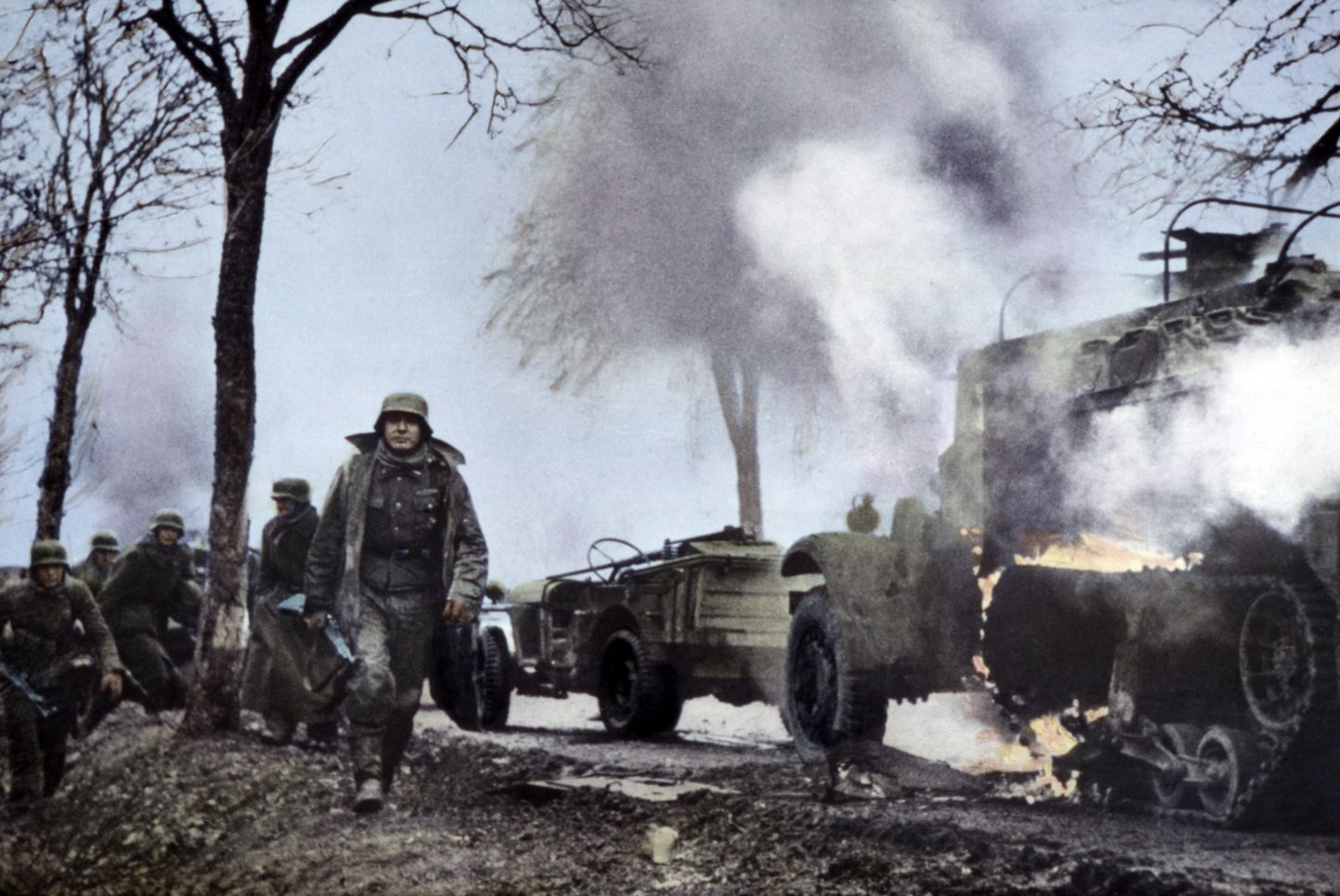 Saksa sõdurid Ardennide vastupealetungi alguses möödumas USA üksuste poolt maha jäetud ja põlevatest masinatest. Kaader sakslaste tehtud filmist millalgi 16.–22. detsembrini 1944