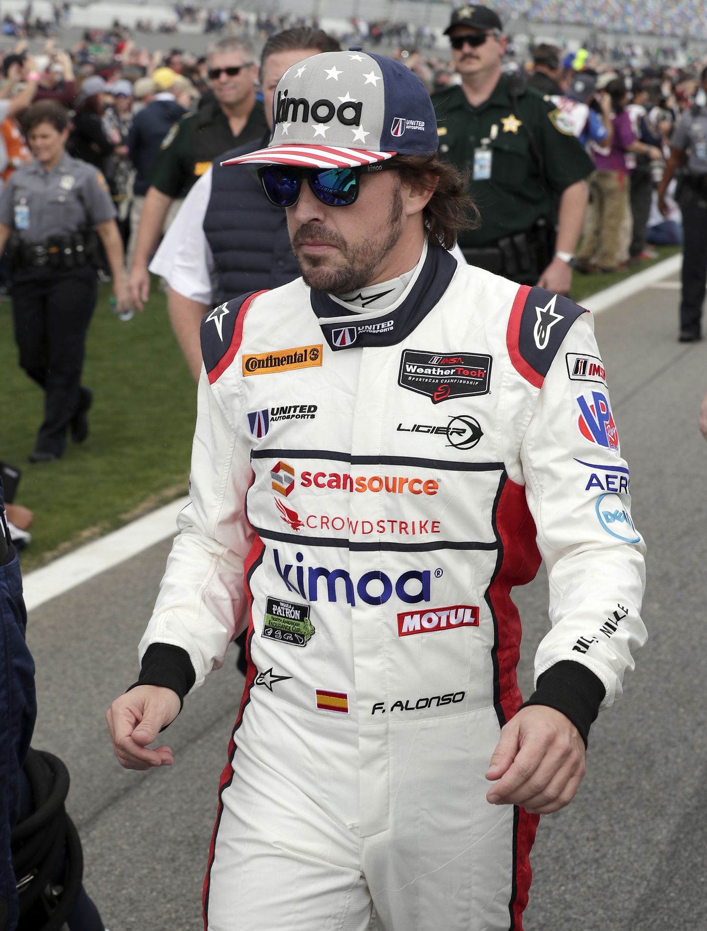 Fernando Alonso, of Spain, walks down pit road to his car before the start of the IMSA 24-hour auto race at Daytona International Speedway, Saturday, Jan. 27, 2018, in Daytona Beach, Fla. (AP Photo/John Raoux)