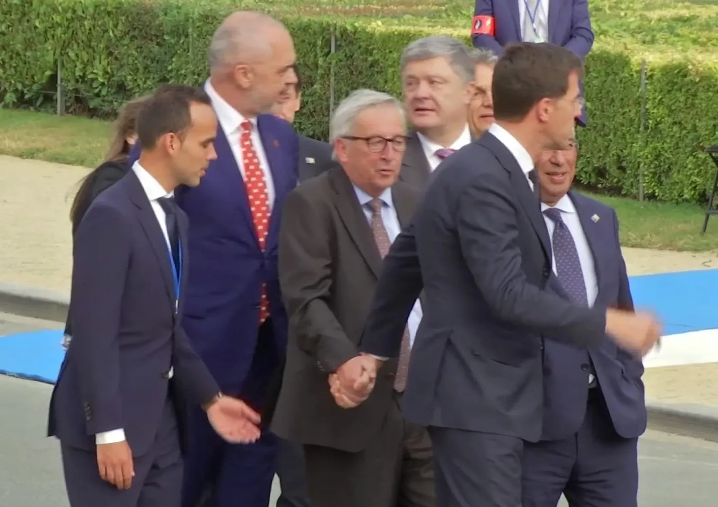 Euroopa Komisjoni president Jean-Claude Juncker saatjaskonna keskel.
