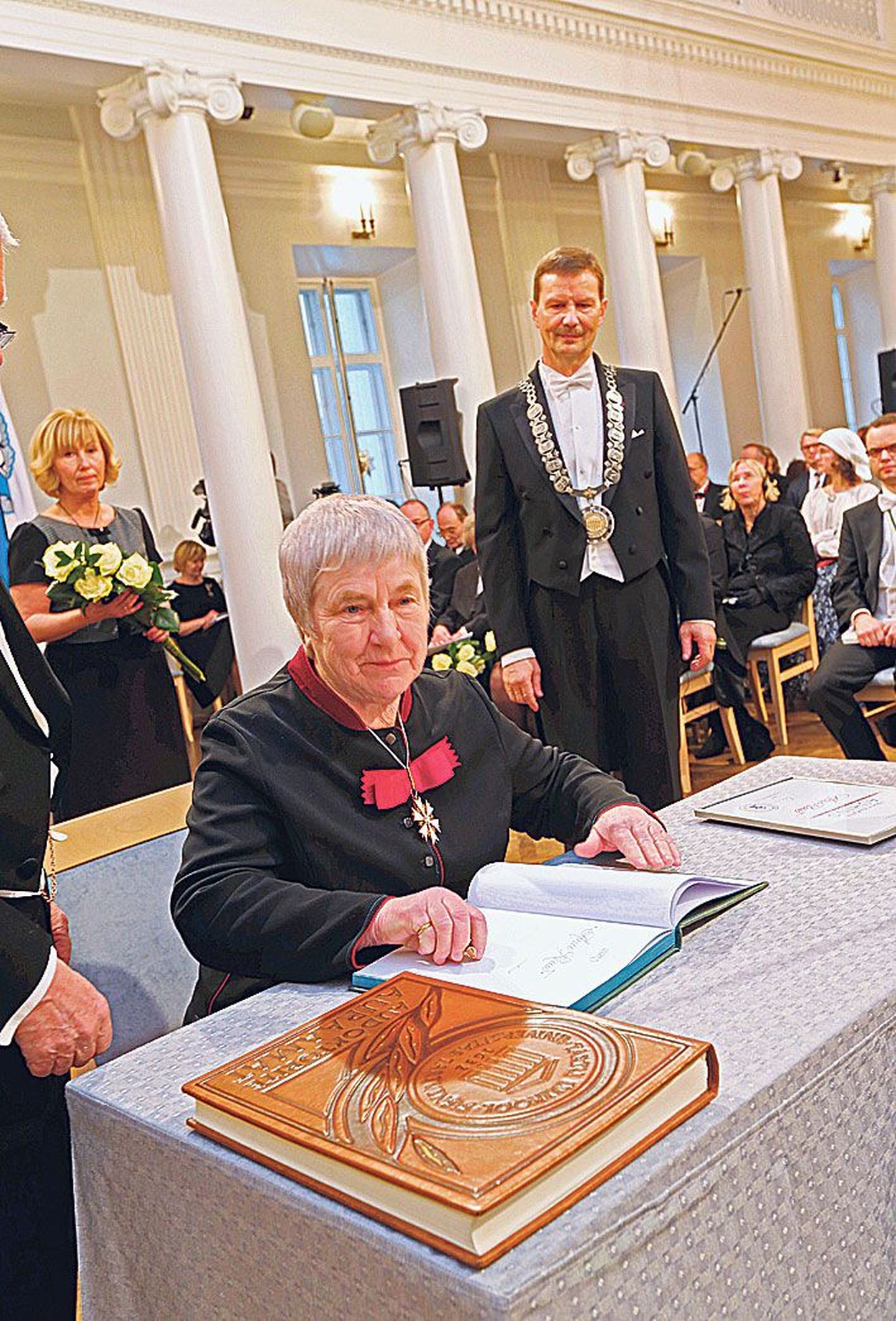 Emeriitprofessor Anu Raud kirjutas Tartu ülikooli rektori Volli Kalmu juuresolekul oma nime auraamatusse.