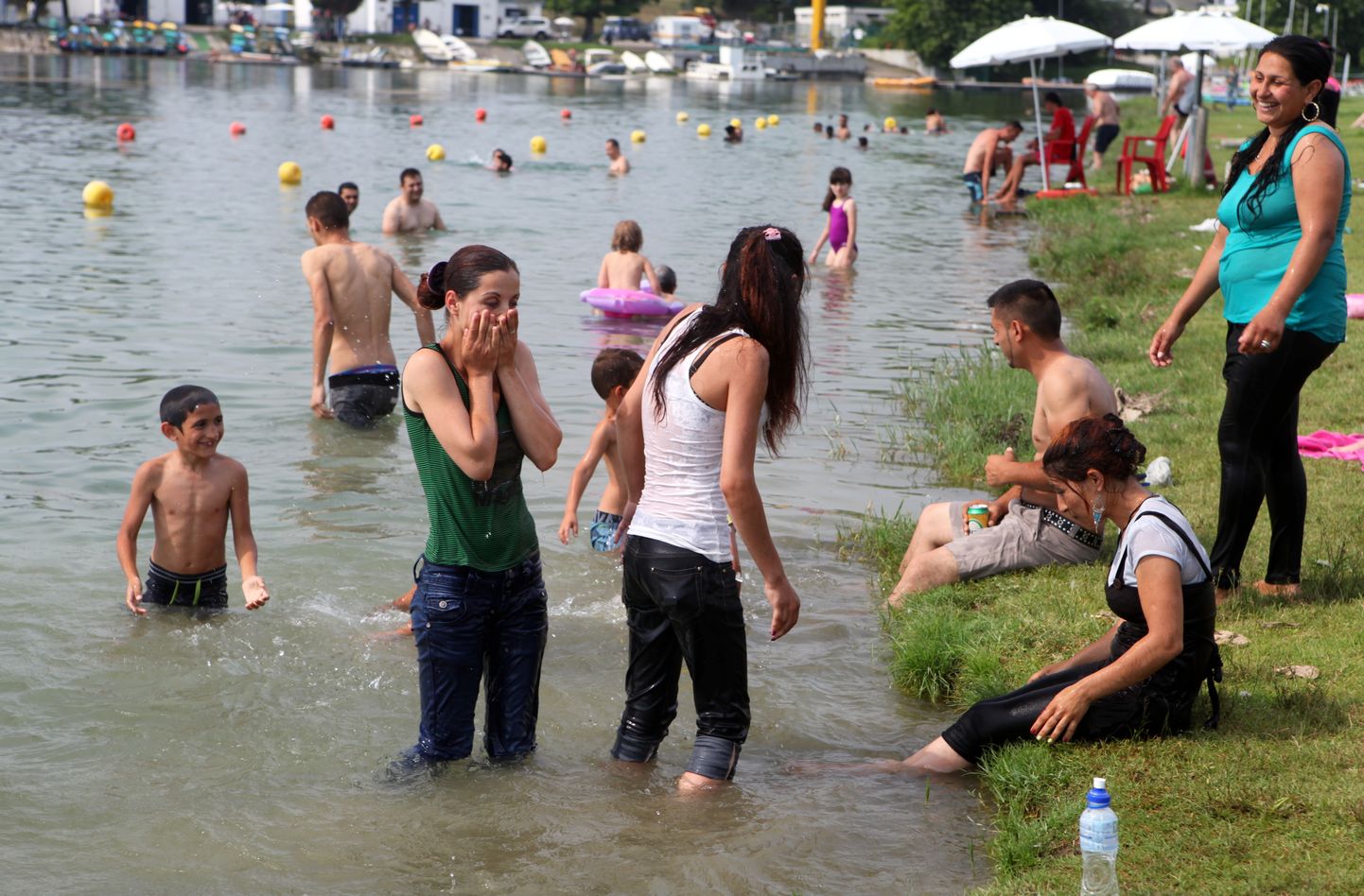 Cilvēki peldas Idroskalo mākslīgajā ezerā netālu no Milānas.