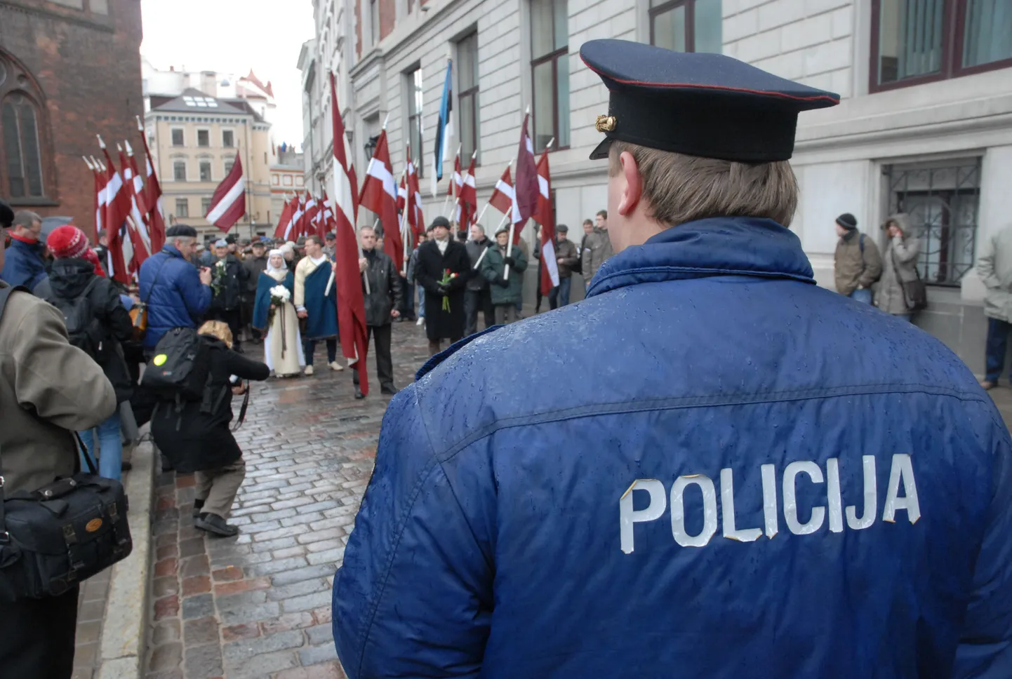 Латвийский полицейский наблюдает за митингом.