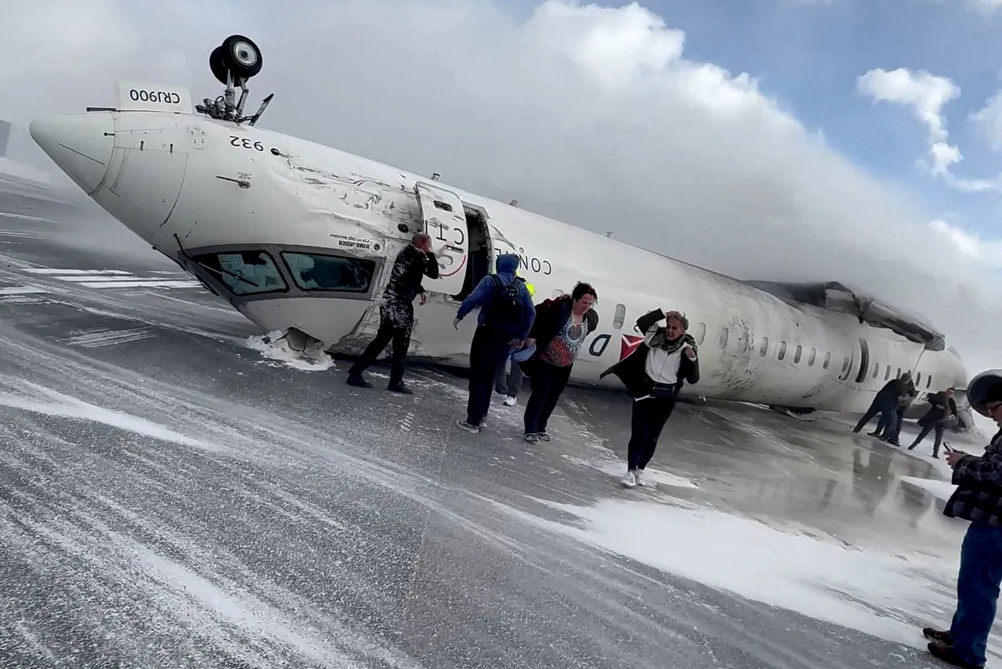 Reisijad lahkuvad Delta Air Linesi katusele pööranud reisilennukist CRJ-900 pärast õnnetust, keegi surma ei saanud.