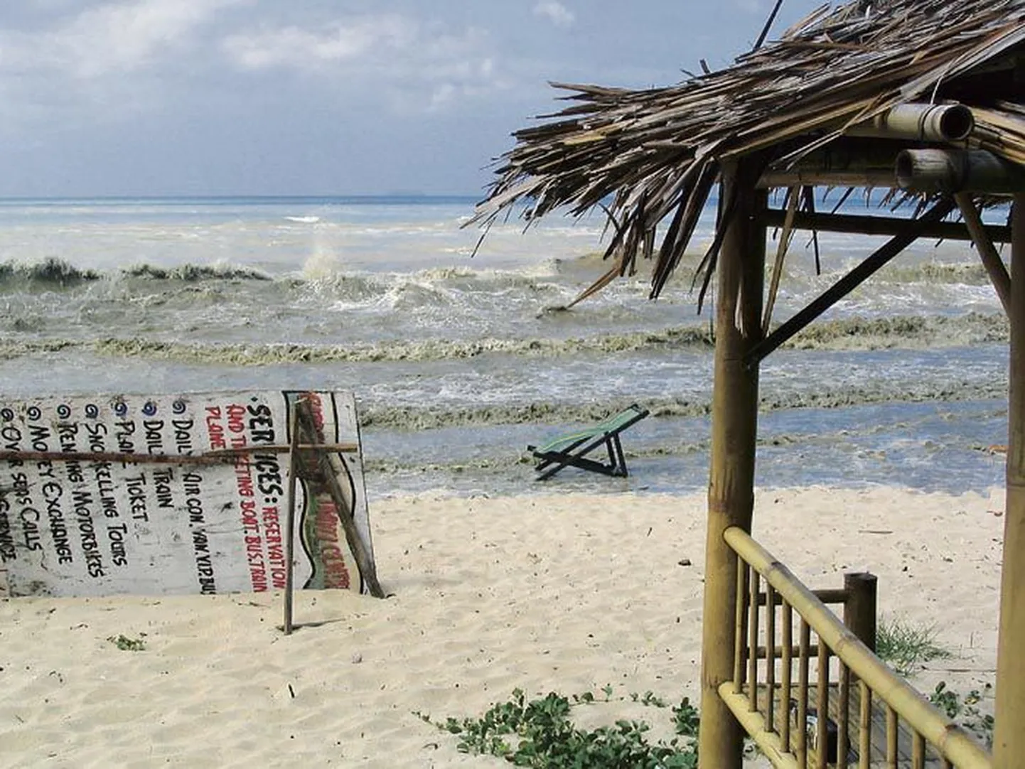Anu Põrgi elukaaslase Mart Normeti foto hetkest, kui eellaine on jõudnud Koh Lanta saare ranna välibaarini. Taamal paistab viiruna hiigellaine, mis juba 30 sekundi pärast purustab rannas kõik, mis ta teel. Sama laine rikkus ka Mardi fotoaparaadi.