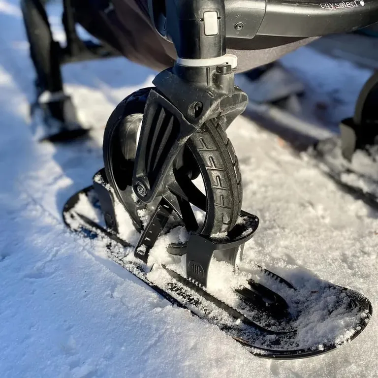 Колеса коляски поставлены на лыжи.