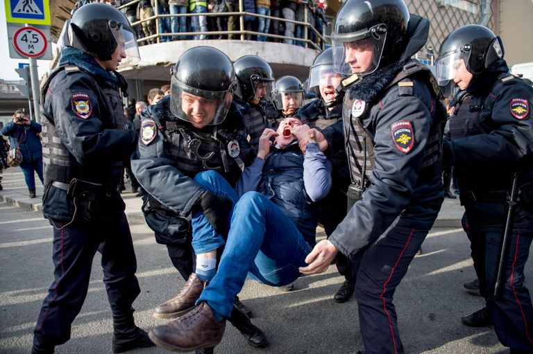 Märulipolitseinikud toimetavad Moskva kesklinnas toimunud korruptsioonivastasel meeleavaldusel osavõtnud noormehe minema. / Scanpix