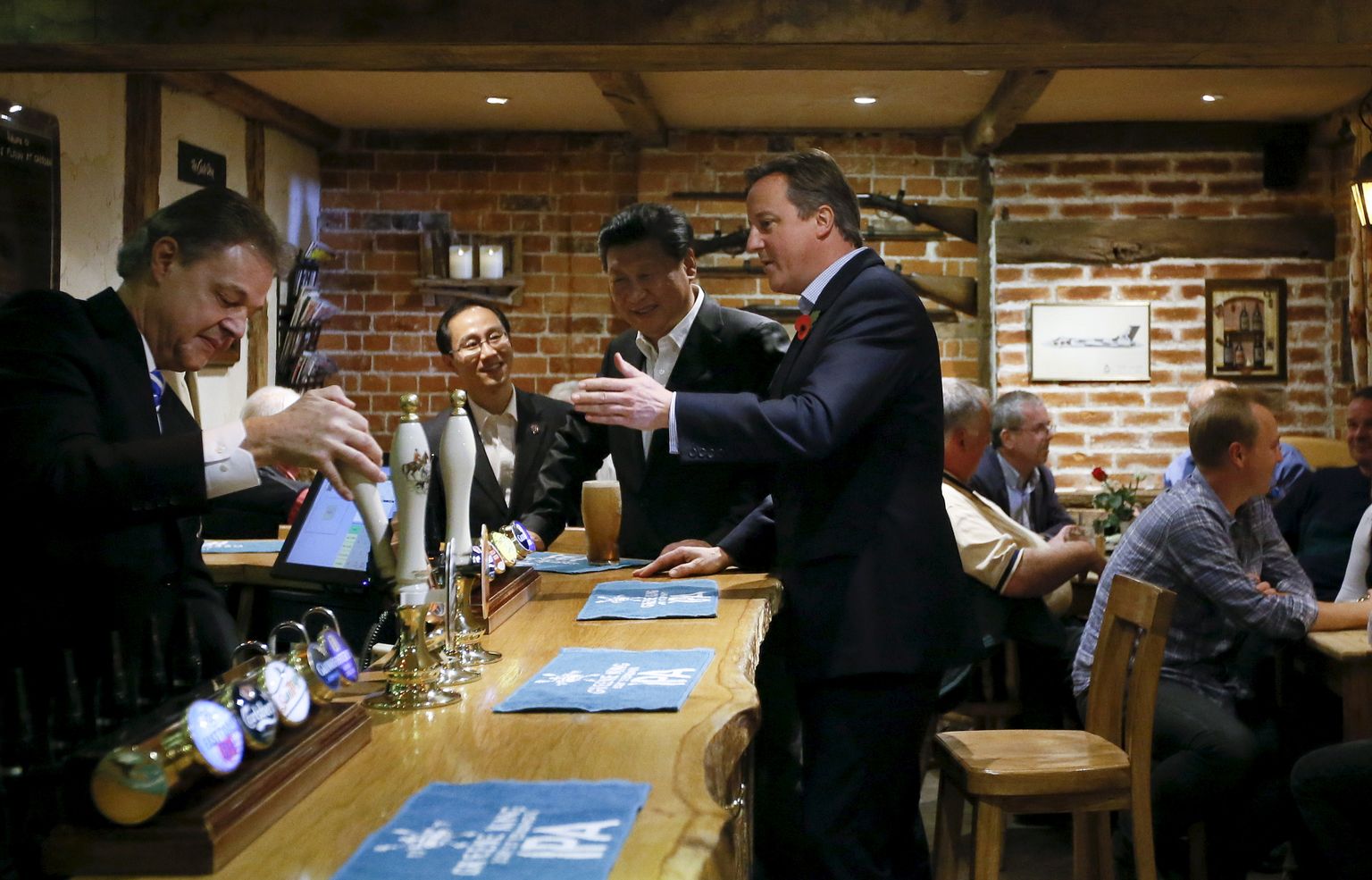 Hiina president Xi Jinping (keskel) 22. oktoobril 2015 koos toonase Briti peaministri David Cameroniga Chequersi lähistel Princes Risborough' pubis õlu pruukimas ja Peking-Londoni suhete kuldajastut välja kuulutamas.