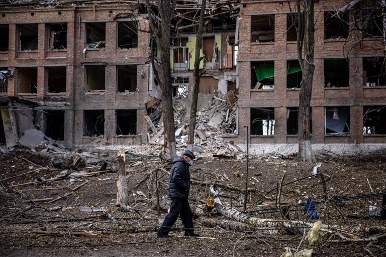 Mees kõnnib 27. veebruaril 2022 Kiievi lähedal Vasylkivi linnas hävinud hoone ees pärast Venemaa raketirünnakut.