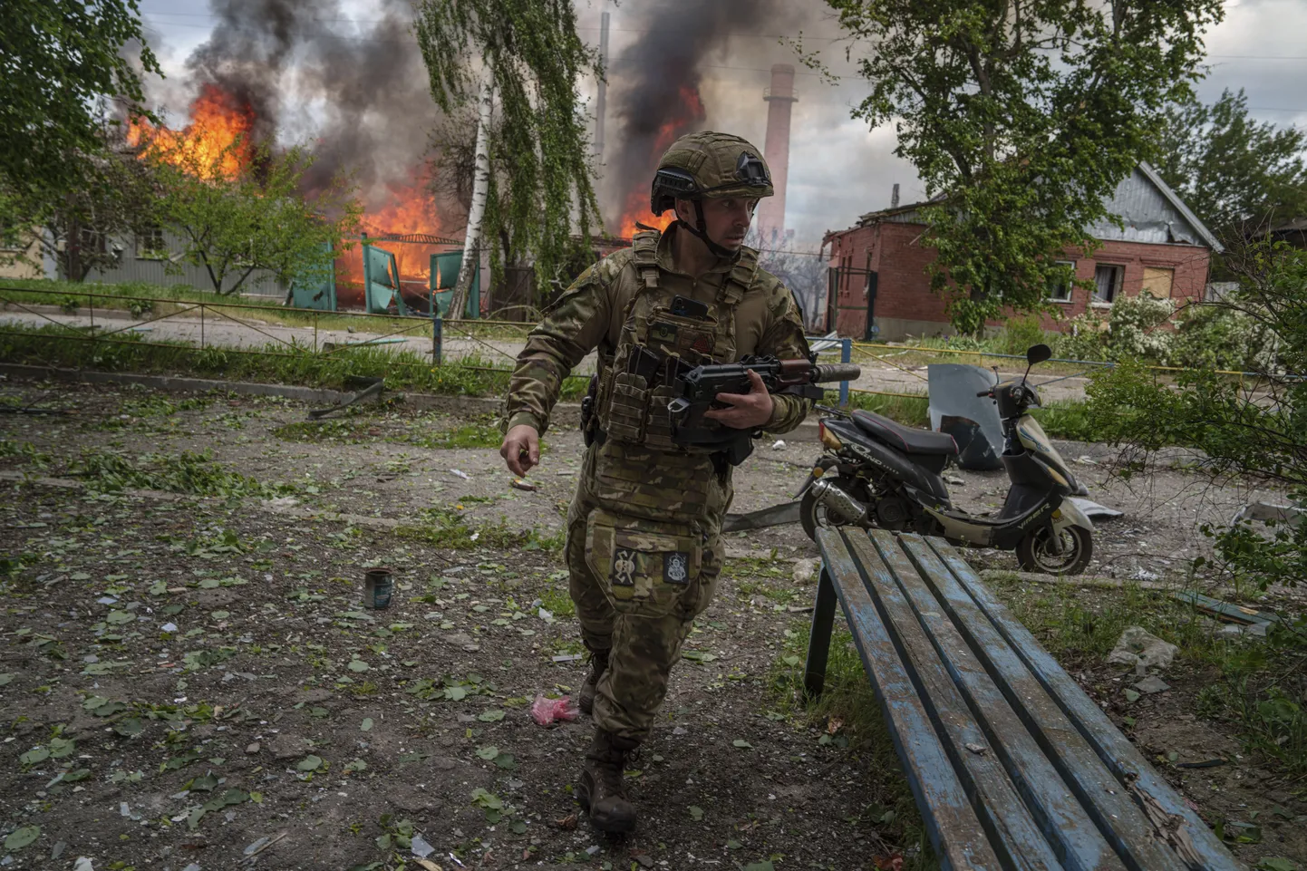 Ukraina sõdur jooksmas Vovtšanskis põleva maja ees, mida on tabanud Venemaa õhurünnak.