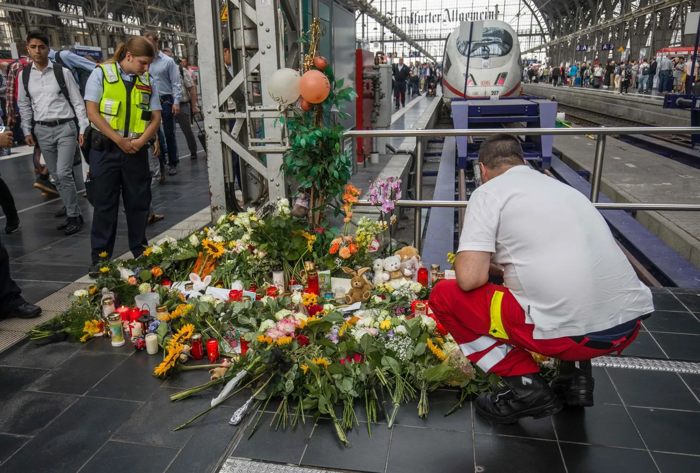 Esmaabitöötaja asetamas eile lilli Frankfurdi raudteejaama 7. perroonile, kust päev varem tõukas keskealine mees saabuva rongi ette ema ja tema kaheksa-aastase poja. Laps hukkus sündmuskohal.