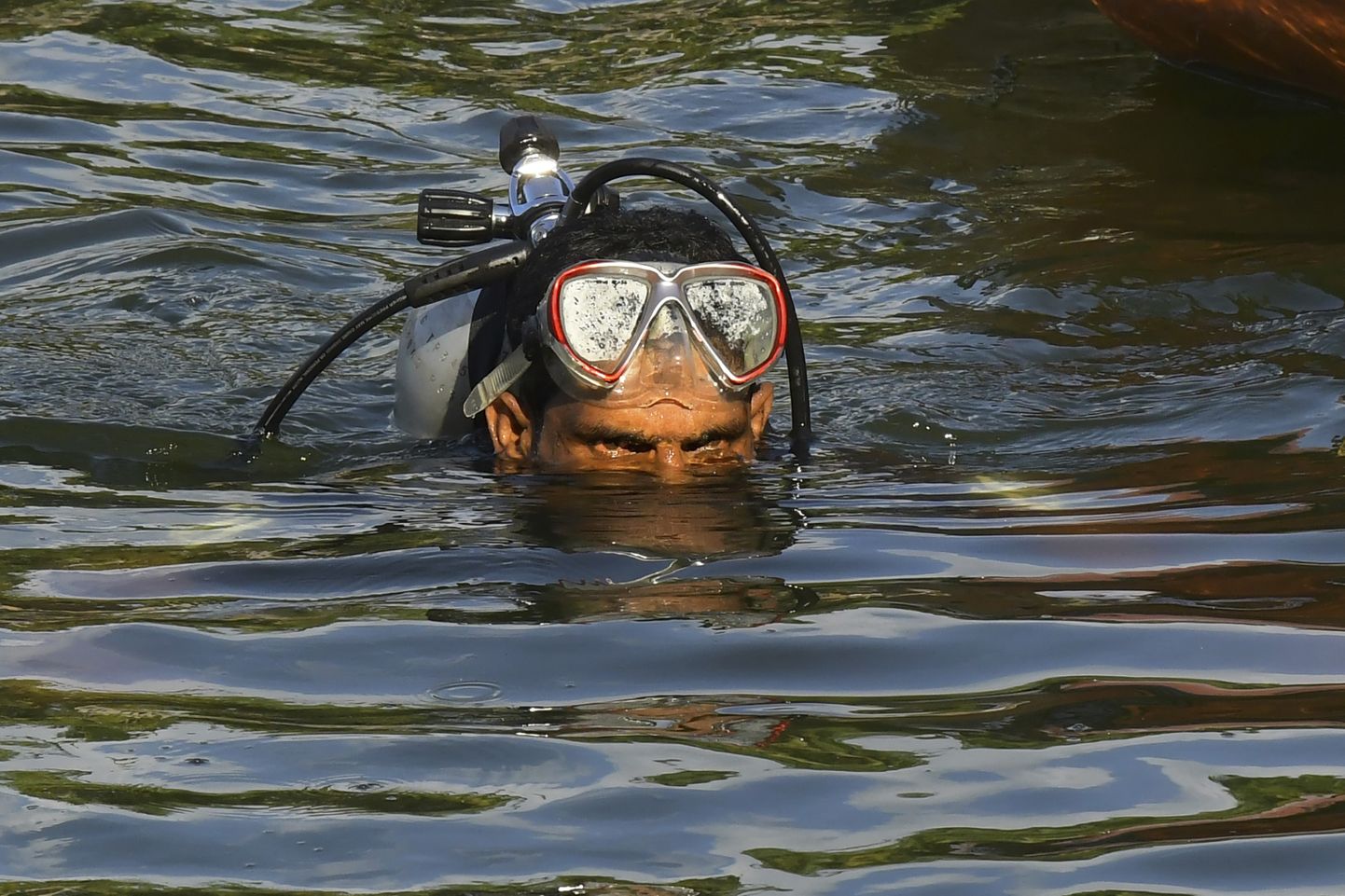 Мужчина переплывает водоем в гидрокостюме. Иллюстративное фото.