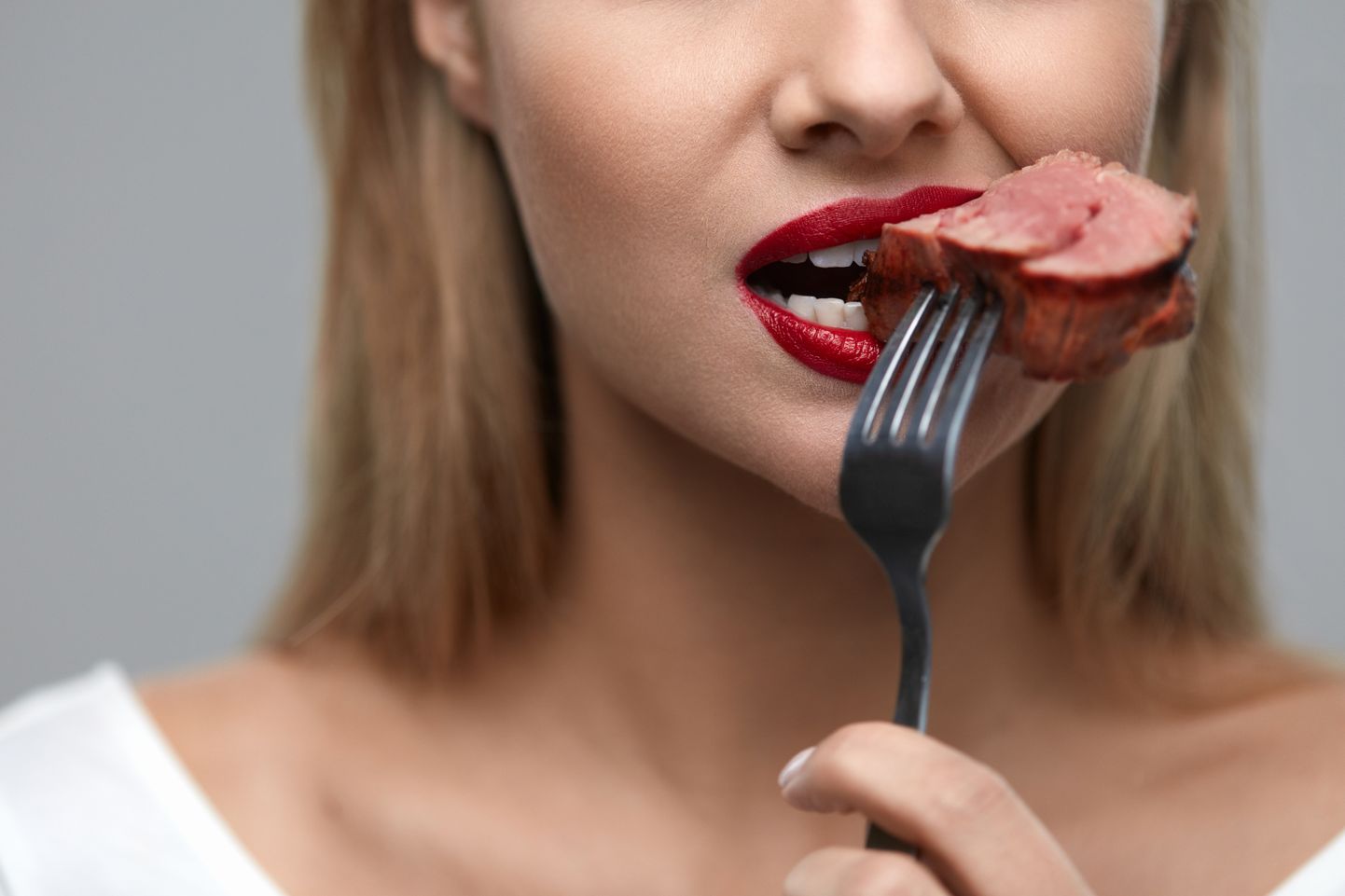 Женщина ест мясо. Иллюстративное фото