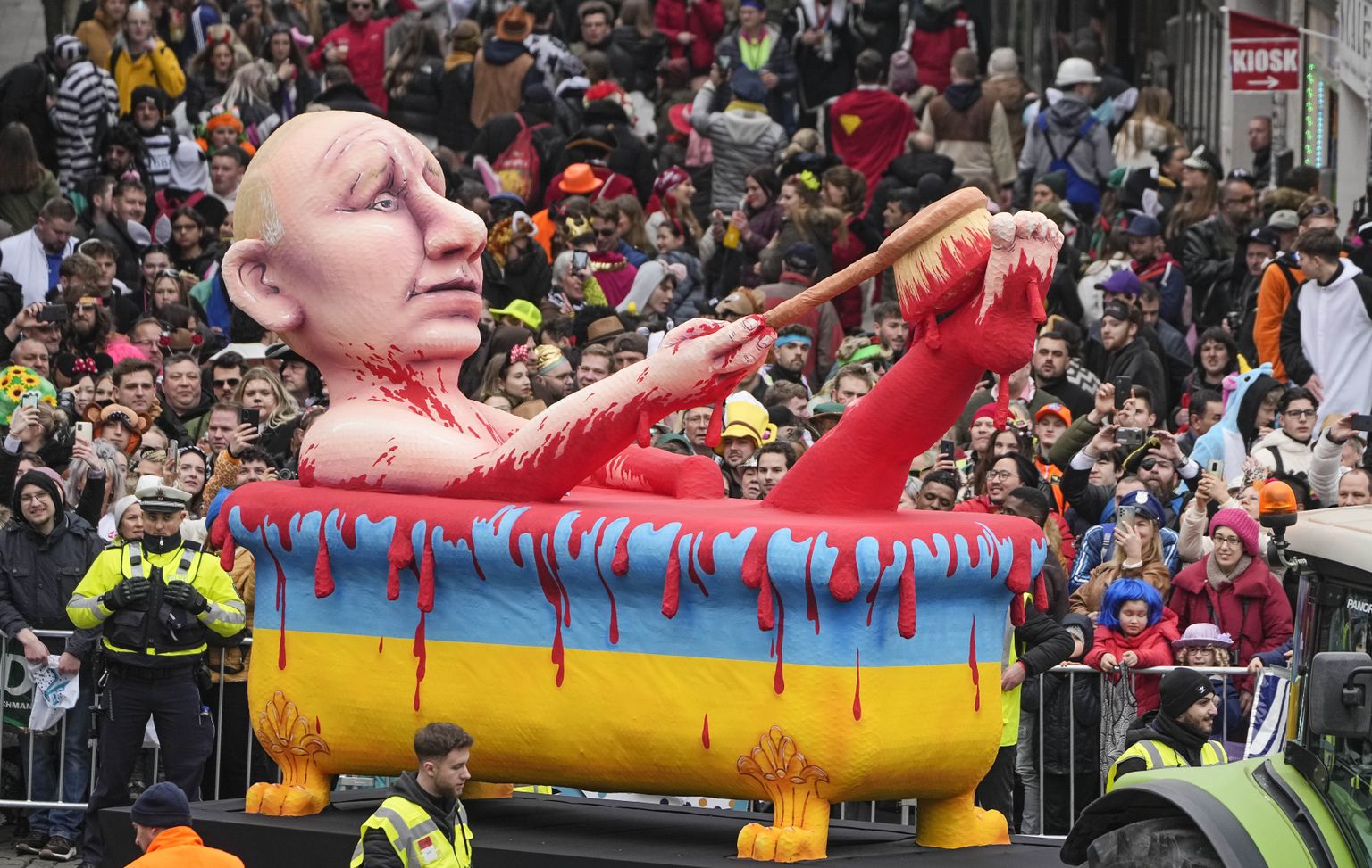 На карнавале в Дюссельдорфе представили платформу с фигурой президента России Владимира Путина, который принимает ванну с кровью, выкрашенную в цвета национального флага Украины, Германия, 20 февраля 2023 года.
