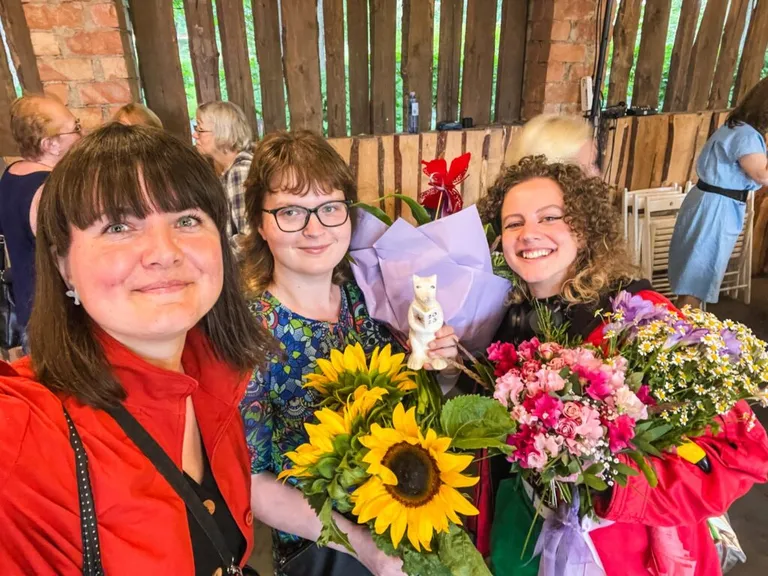 No kreisās: kustības “Volūda” vadītāja Edeite Laime, rakstniece Laura Melne un ilustratore Vivianna Marija Stanislavska Jāņa Baltvilka balvas pasniegšanā 2023. gada jūlijā.