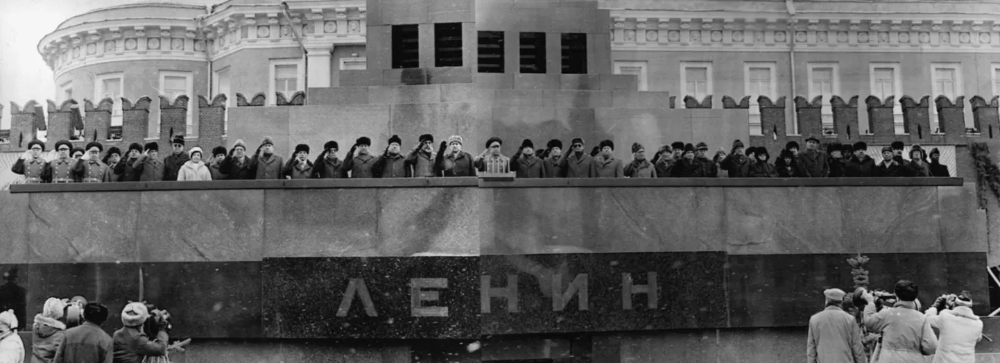 Kaks korda aastas – 9. mail ja 7. novembril – upitati kommunistide liidrid tribüünile Lenini surnukeha kohal. See pilt on tehtud 1987. aastal, kui kommunistide korraldatud riigipöördest Venemaal oli möödunud 70 aastat. Pole teada, kas kõik võimutaadid on selle pildi peal õiges järjekorras, sest eelneval päeval peeti pidu ohtra alkoholiga ning vahipataljoni ajateenijatel ei pruukinud nende mehikeste õiges järjekorras tribüünile upitamine õnnestuda.