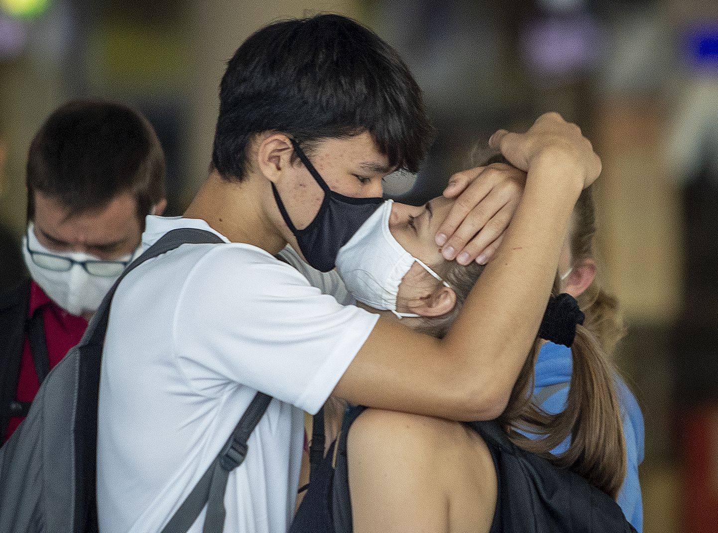 Läbi maskide suudlev paarike 2020. aastal Frankfurti lennujaamas.