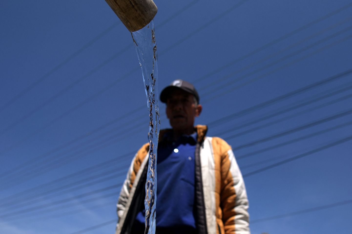 Kohalik mees kogub Bogota lähistel La Caleras joogivett.
