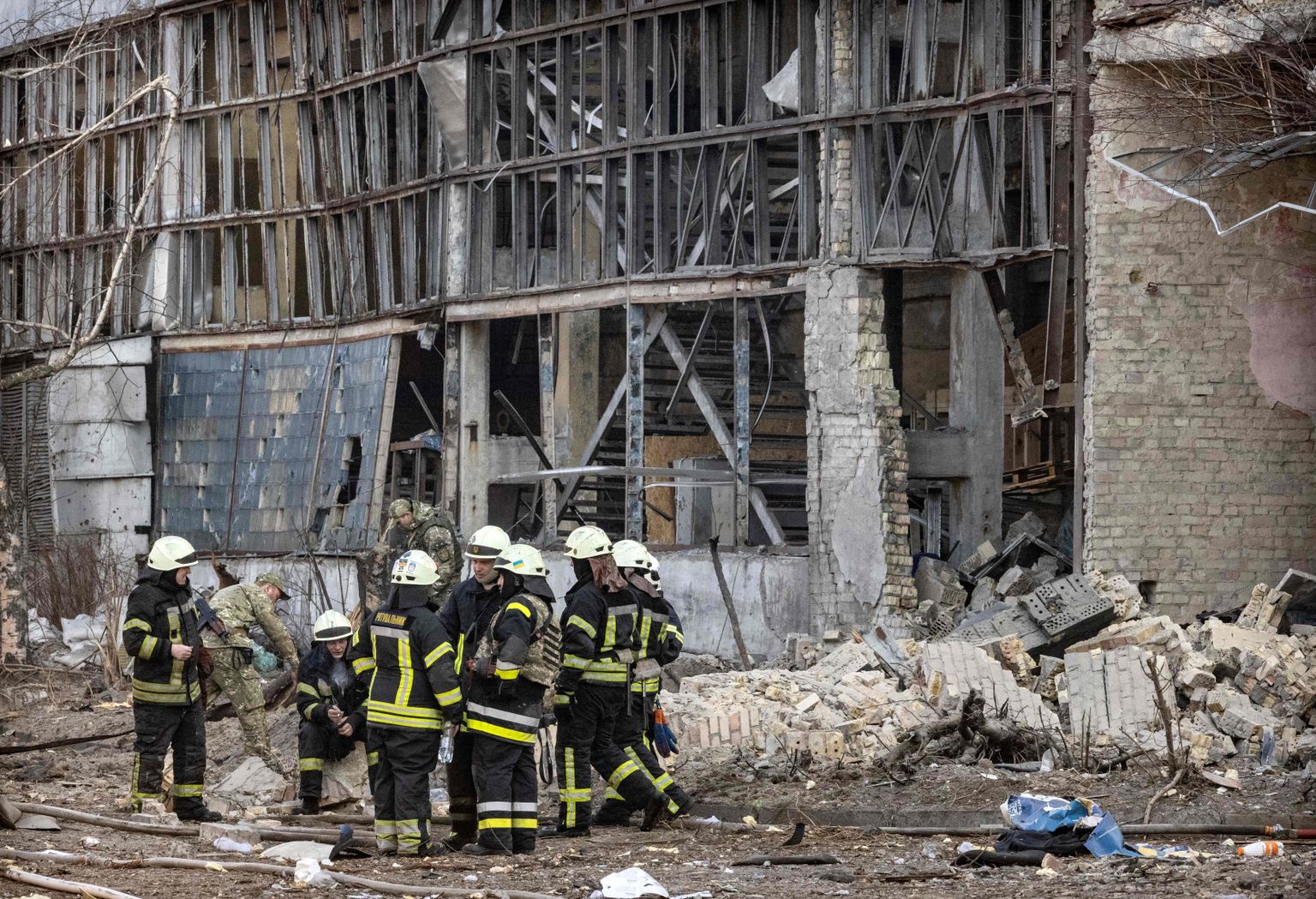 Firefighters sit amid debris in the area of a research institute, part of Ukraine's National Academy of Science, after a strike by drones that killed at least one, in northwestern Kyiv, on March 22, 2022. - Russians reinforce their positions around the capital which has not yet been fully surrounded on the 27th day of the assault (Photo by FADEL SENNA / AFP)