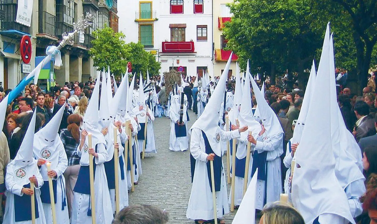 Maani mantlid ja kõrged koonusjad peakatted-maskid, mille silmaavadest vaatavad vastu tumedad pilgud. Tõrvikute ere valgus ja suits. Aeglaselt õõtsudes liigub ähvardav rongkäik läbi linna. Ei, see pole siiski Ku Klux Klani liikmete kogunemine, vaid lihavõtted Sevillas.