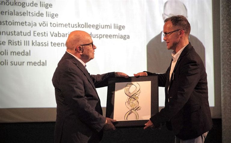 Eesti inimesegeneetika ühingu president Neeme Tõnisson õnnitleb elutööpreemia saajat professor Raivo Uibot.