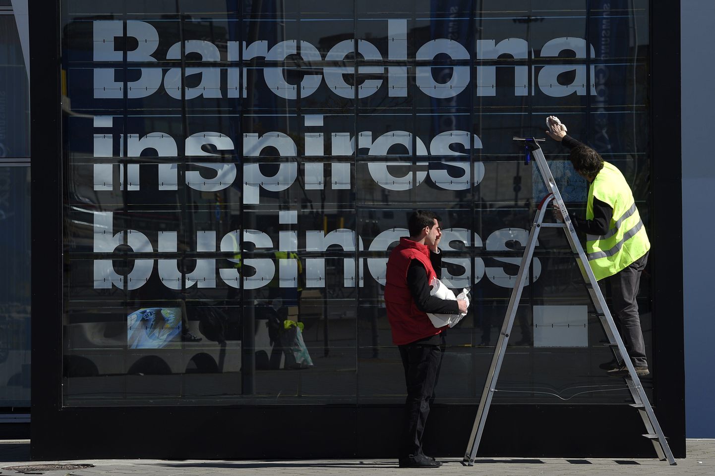 Töölised sätivad paika Barcelona mobiilitootjate kongressi plakatit. Hispaania suutis euroala riikidest aastaga oma töötust enim vähendada.