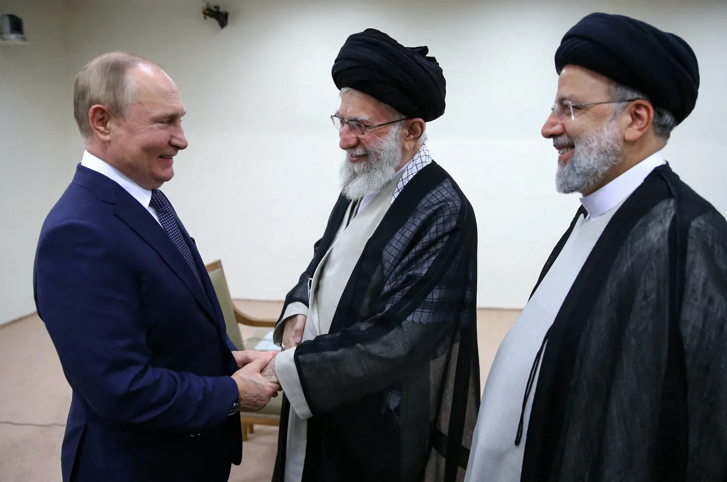 Путин радуется рукопожатию с духовным лидером Ирана Али Хаменеи на встрече в Тегеране в 2022 году. Президент Ирана в 2021-2024 годах Ибрахим Раиси стоит рядом.