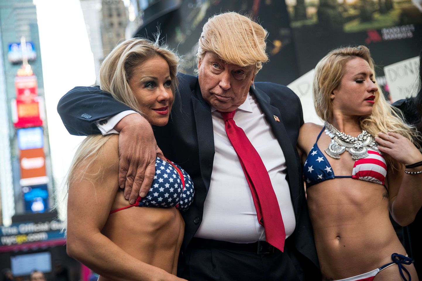 Donald Trumpiks kehastunud mees bikiinides naistega. Pilt on illustreeriv.
