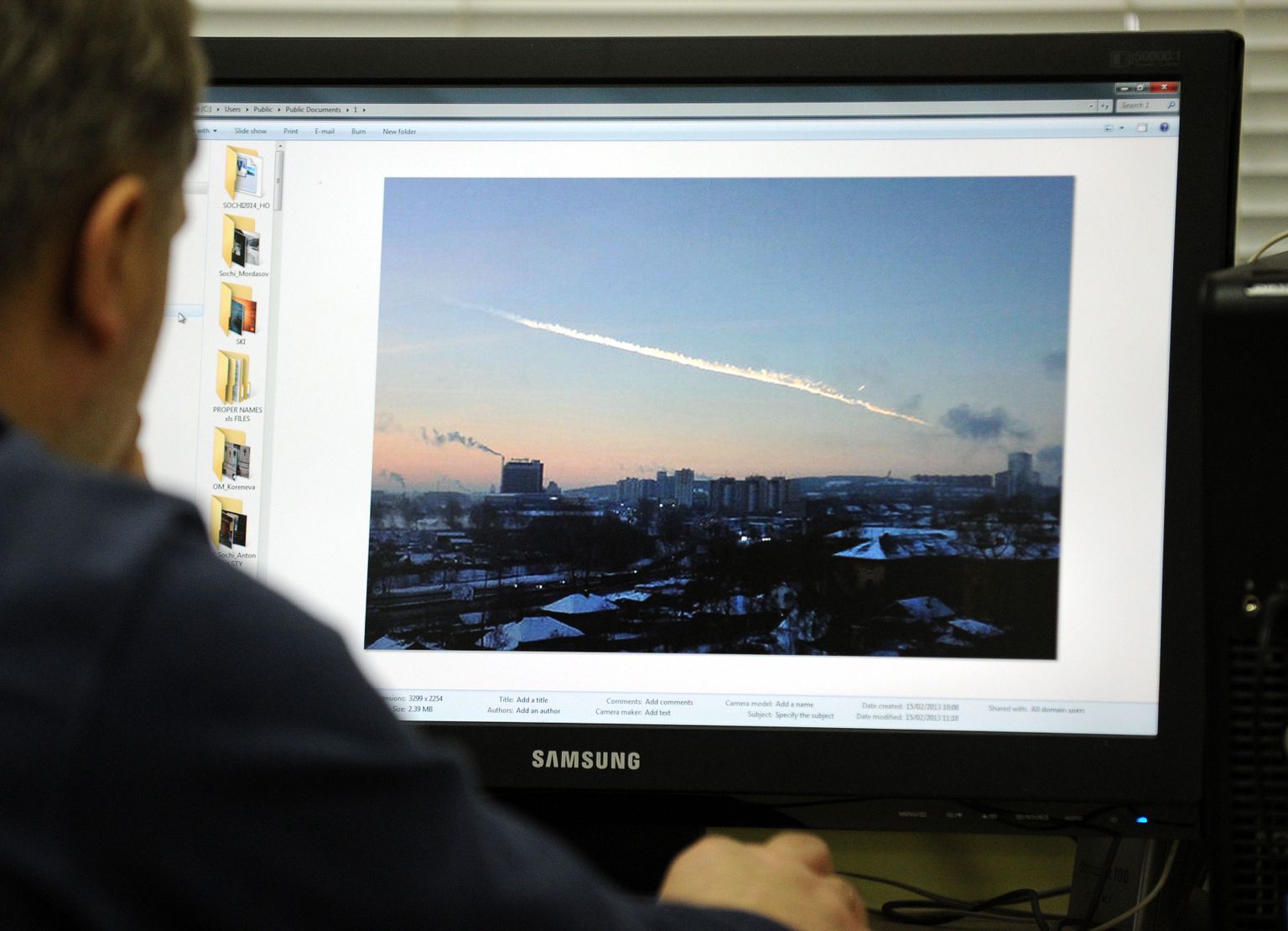 Mees uurib arvutist meteoriidisadu Tšeljabinskis.
