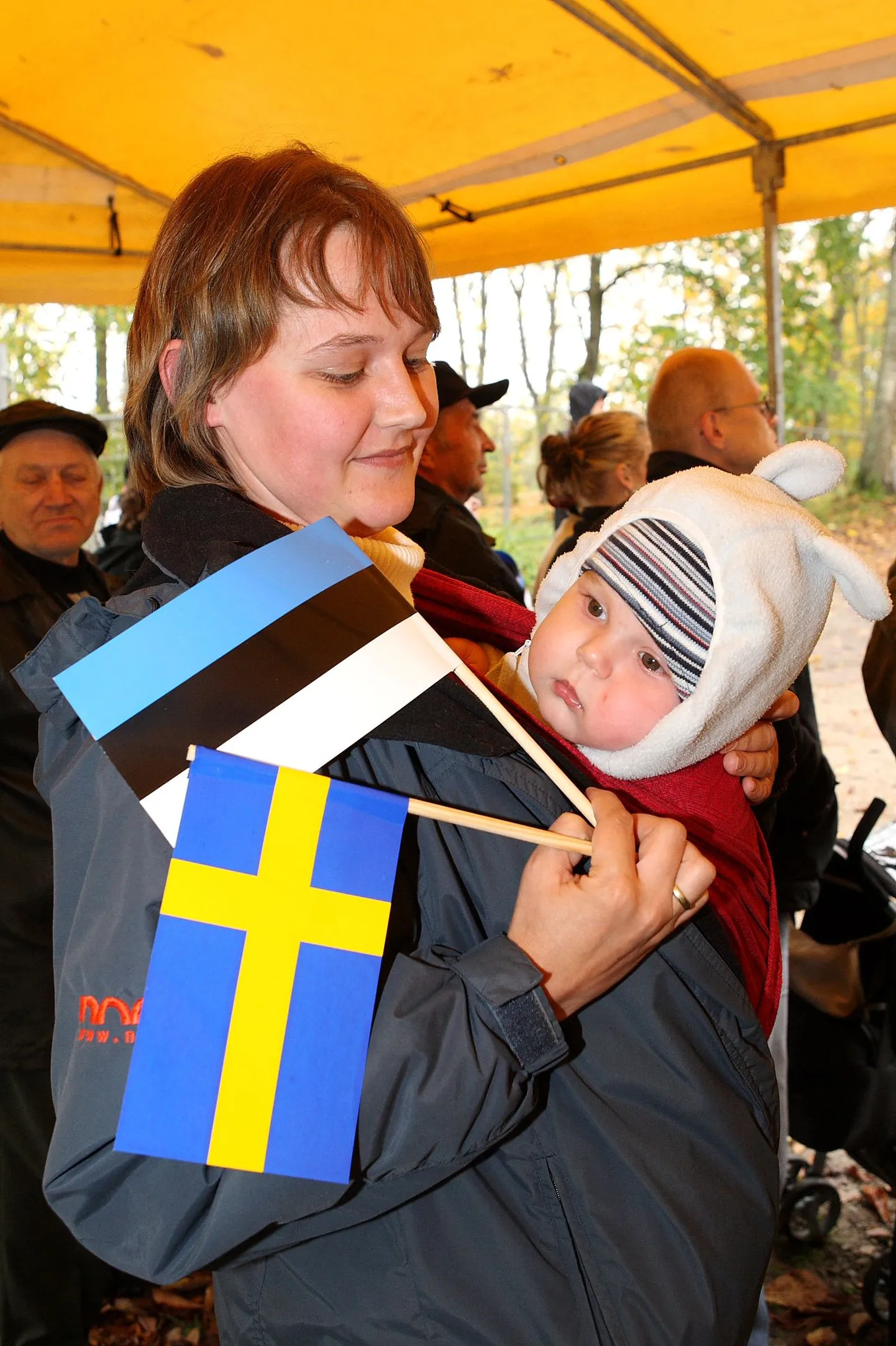 Ema ja laps Eesti ja Rootsi lippudega