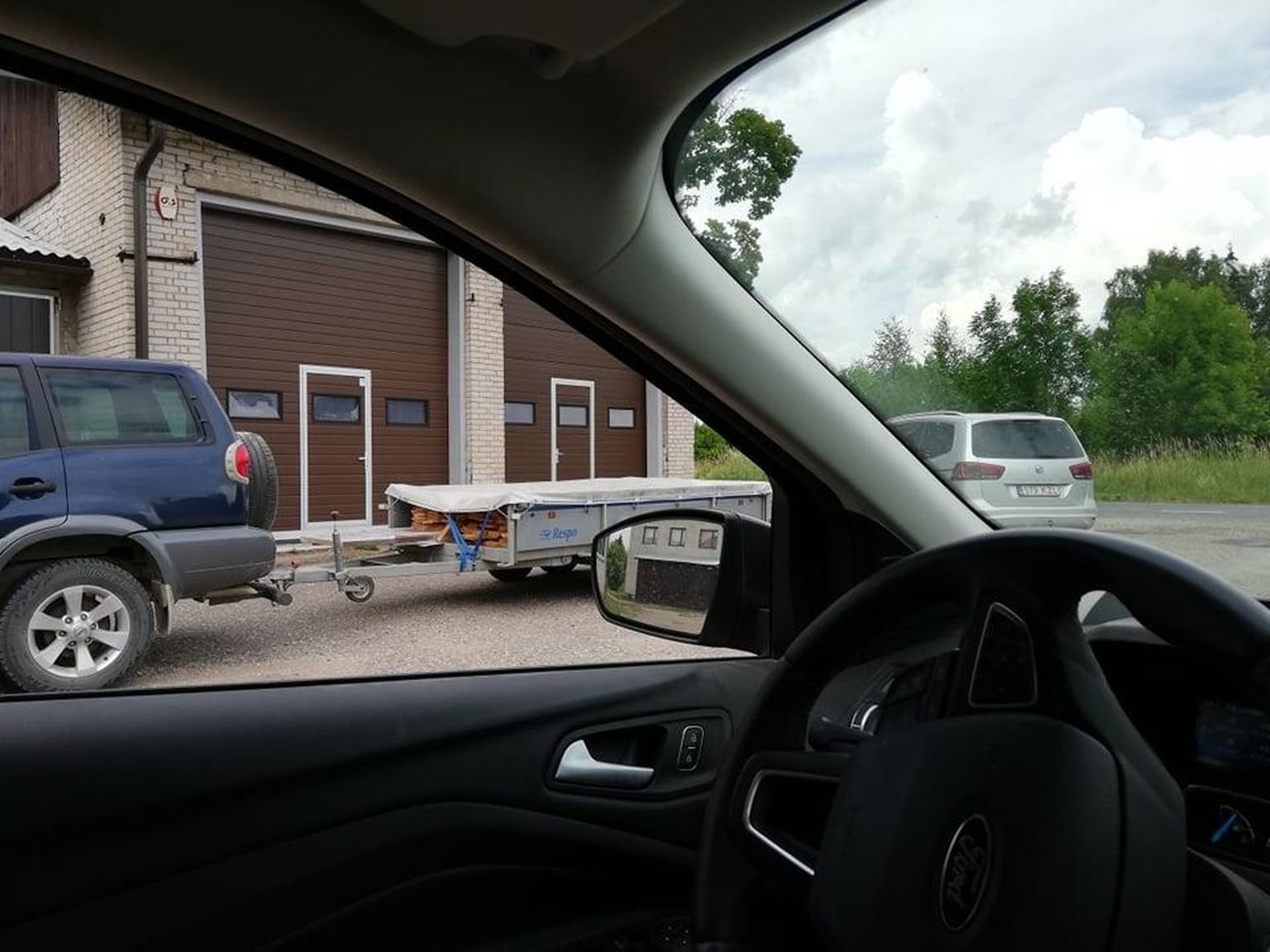 Автомобиль директора центра профессионального образования Вырумаа Танеля Линнуса с прицепом, набитым столами, у школьных гаражей.
